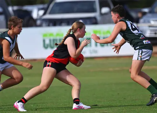 Waaia footballers contest the ball against a side in green