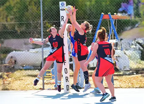 Waaia netballers contest a rebound under the goal post